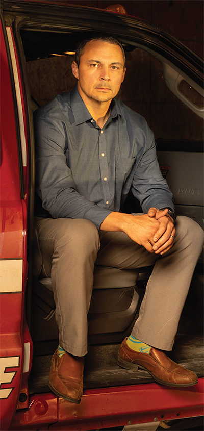 Man sits on edge of seat in firetruck with open door