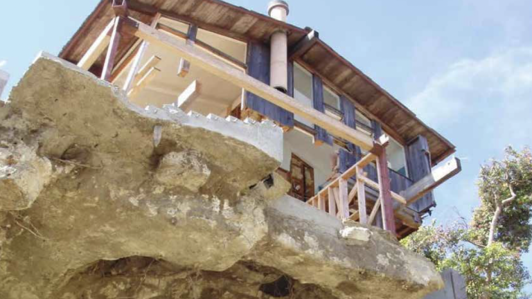 House hangs over the edge of a crumbling cliff