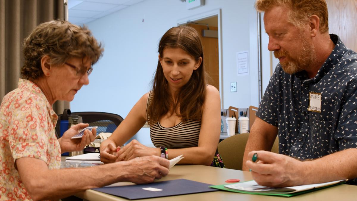 A team of three teachers reviews print material 