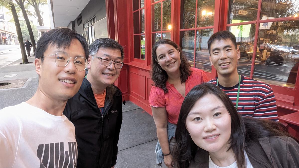A group of researchers pose for a selfie on a city sidewalk
