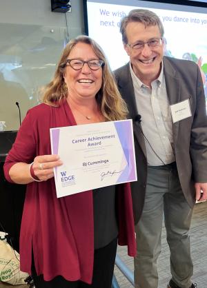 Two people pose with a Career Achievement cerrtificate